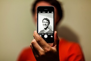 תמונת איש מחייך על מסך סמארטפון